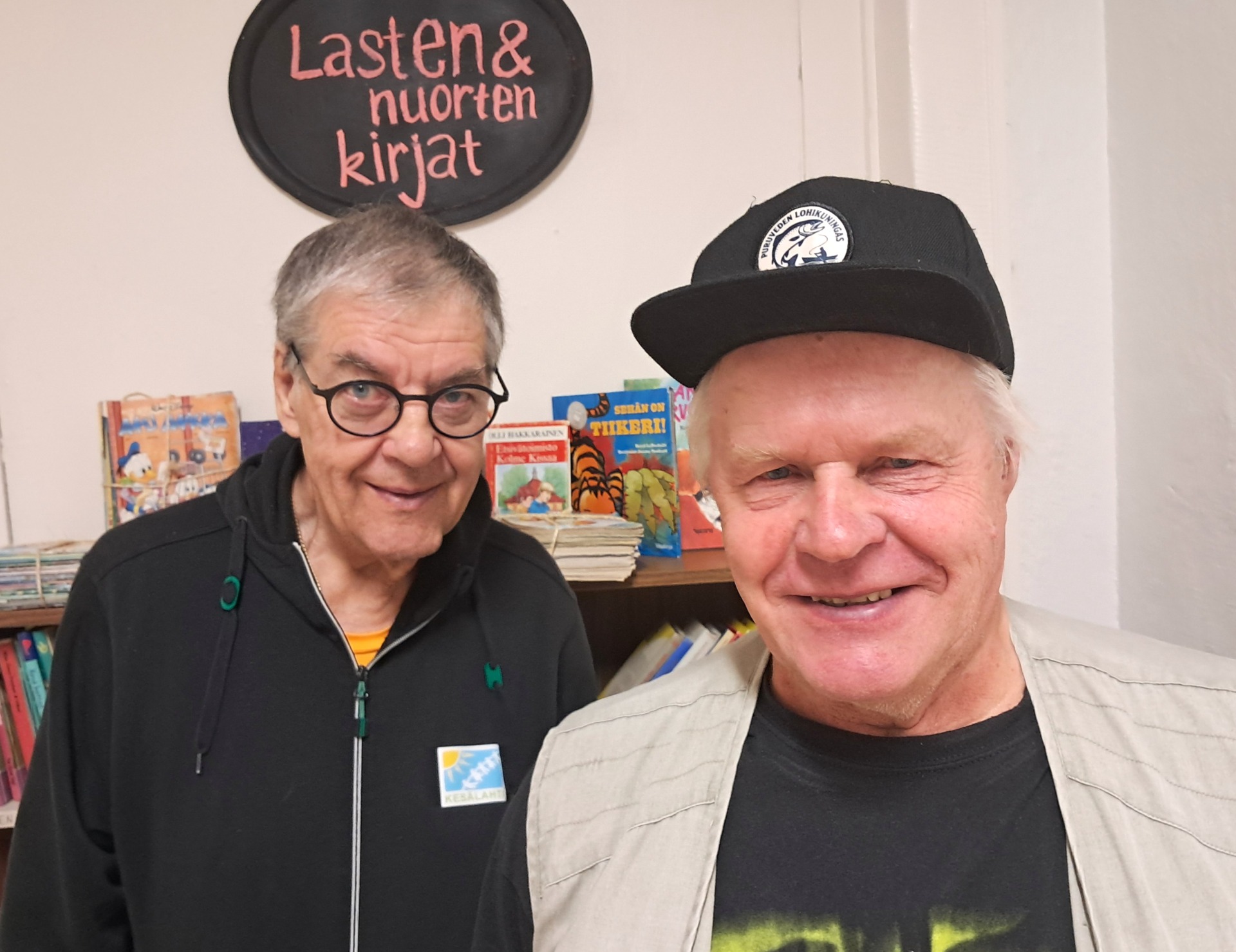 Suojakäsineet kädessä porataan kaappia, taustalla työkalut ja hylly.